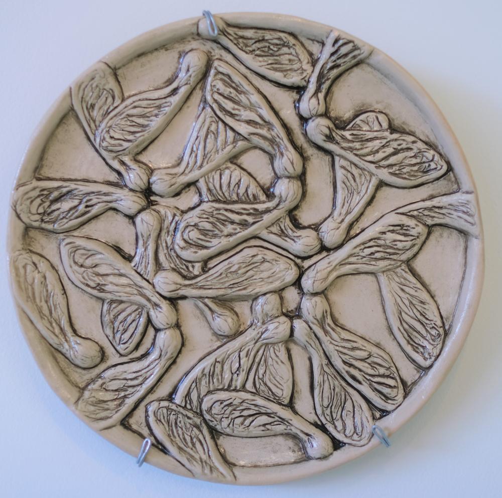 Round ceramic covered in sycamore seeds