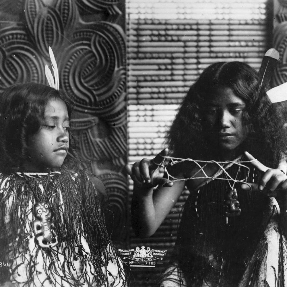 New Zealand. Tourism Department.  Maori girls playing a string game. Original photographic prints and postcards from file print collection, Box 3.  Ref: PAColl-5671-34. Alexander Turnbull Library, Wellington, New Zealand /records/22710365